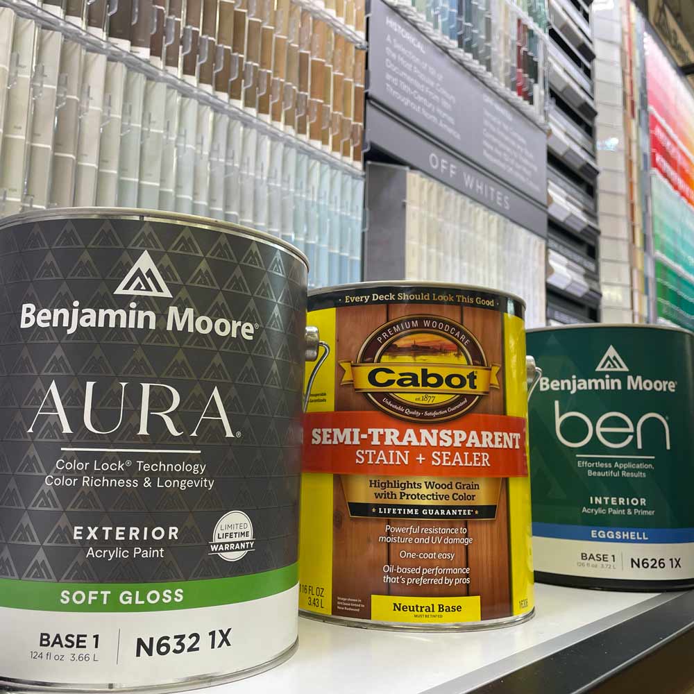 Benjamin Moore and Cabot paint cans in front of a paint display