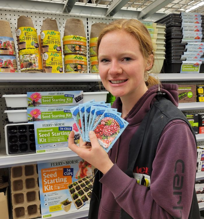 Young Woman Holding Packets of Seeds