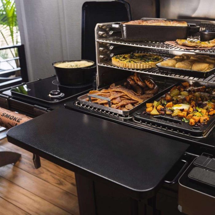 Traeger grill with food on it and shelf