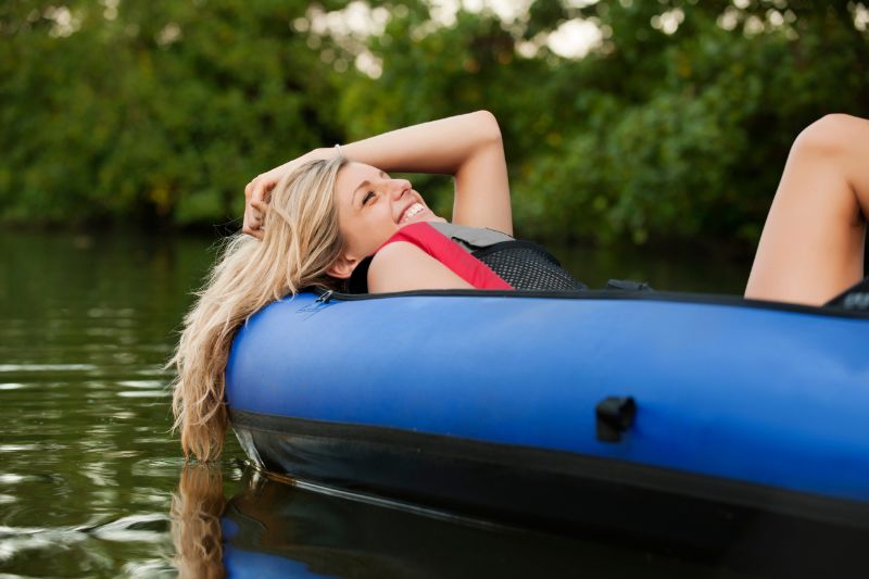 Woman relaxes on a raft while floating on a river in Montana